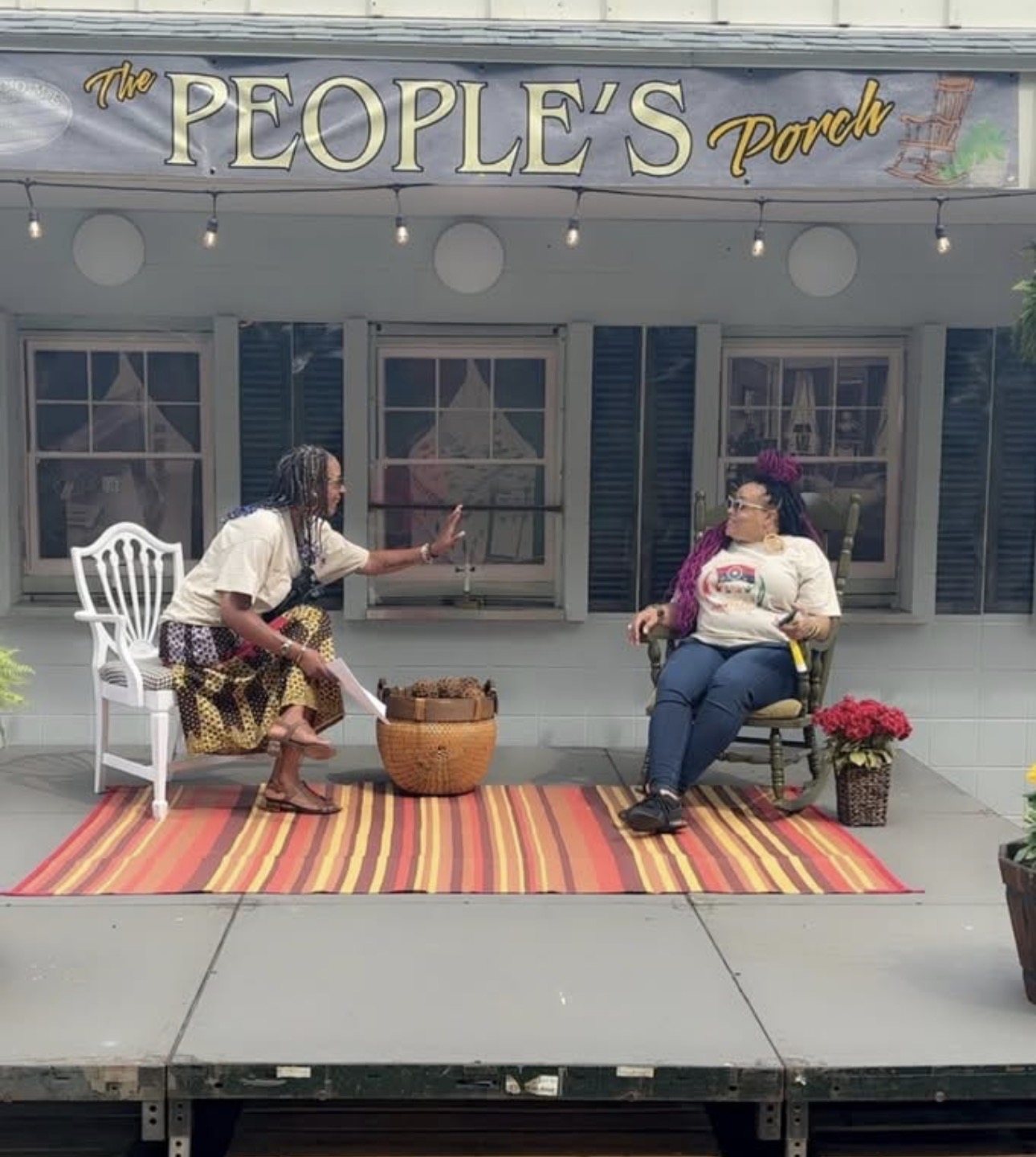 Community conversation on The People's Porch beneath the festival banner
